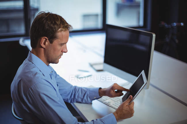 focused_228968042-stock-photo-businessman-using-digital-tablet-desktop